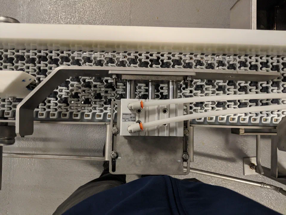 The clamp assembly installed over the existing conveyor