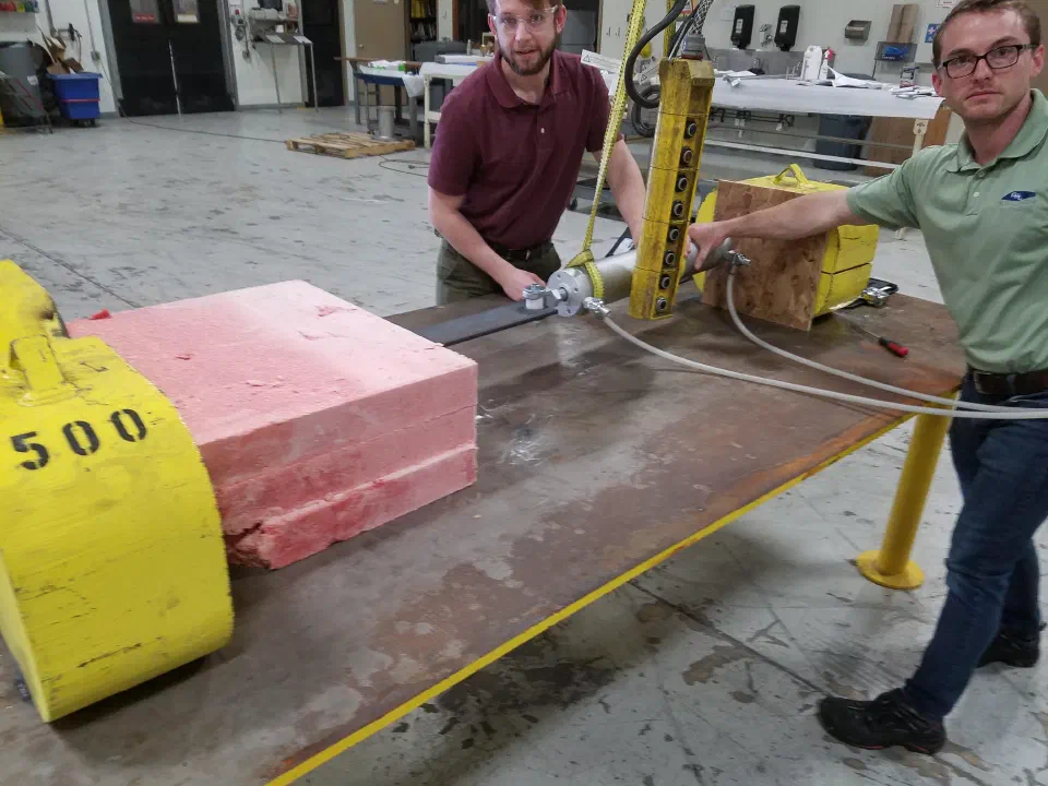 Phil and a coworker pushing a frozen block against a reaction weight during a force test