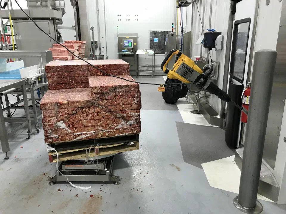 The problem: a pallet of frozen blocks fused together in transit, with the jackhammer an operator used to break them apart