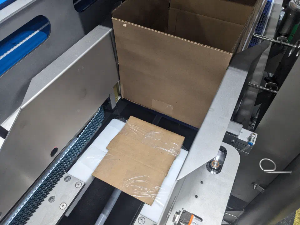 The robot placing a bag into an open case