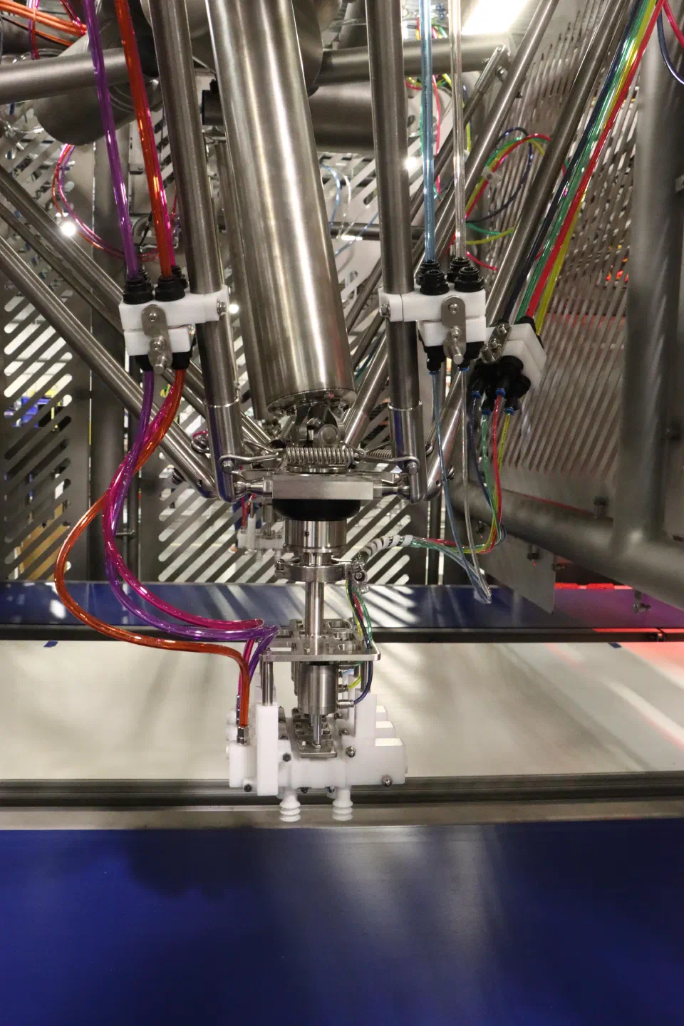 The primary pick tooling's twin end-effector heads with pneumatic and vacuum lines