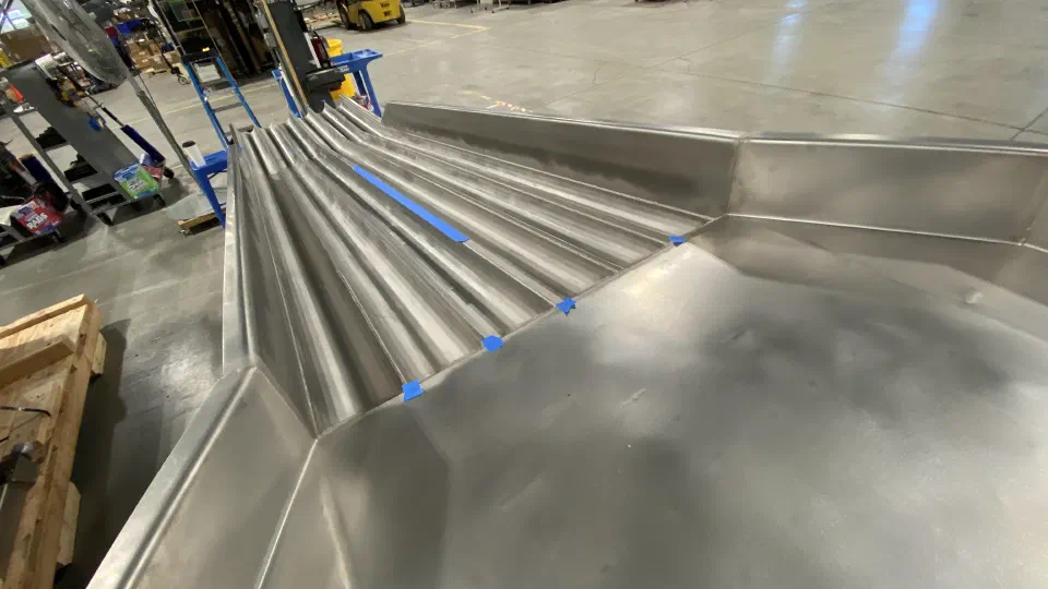 A feeder trough as received, with weld defects flagged