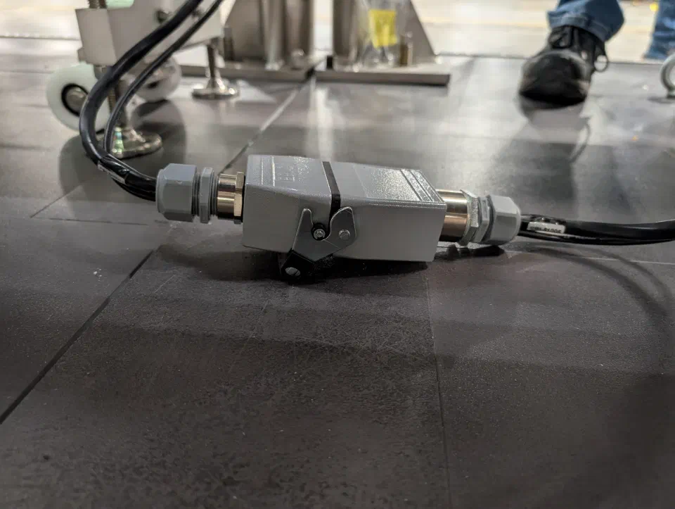 A quick-disconnect on the forming cell's cable and hose umbilical, one of the teardown points for shipping