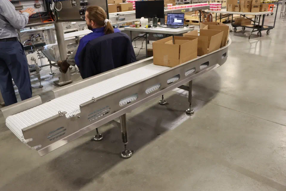 Erected cases on the case turn conveyor during shop buildup