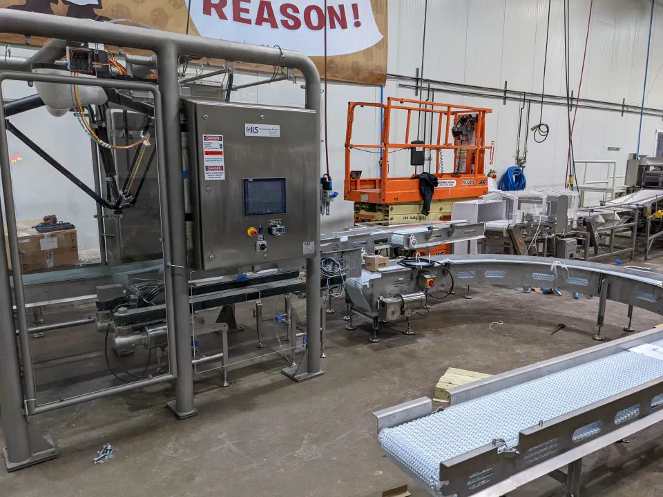 The robotic case packing cell during installation, beside the case turn conveyor