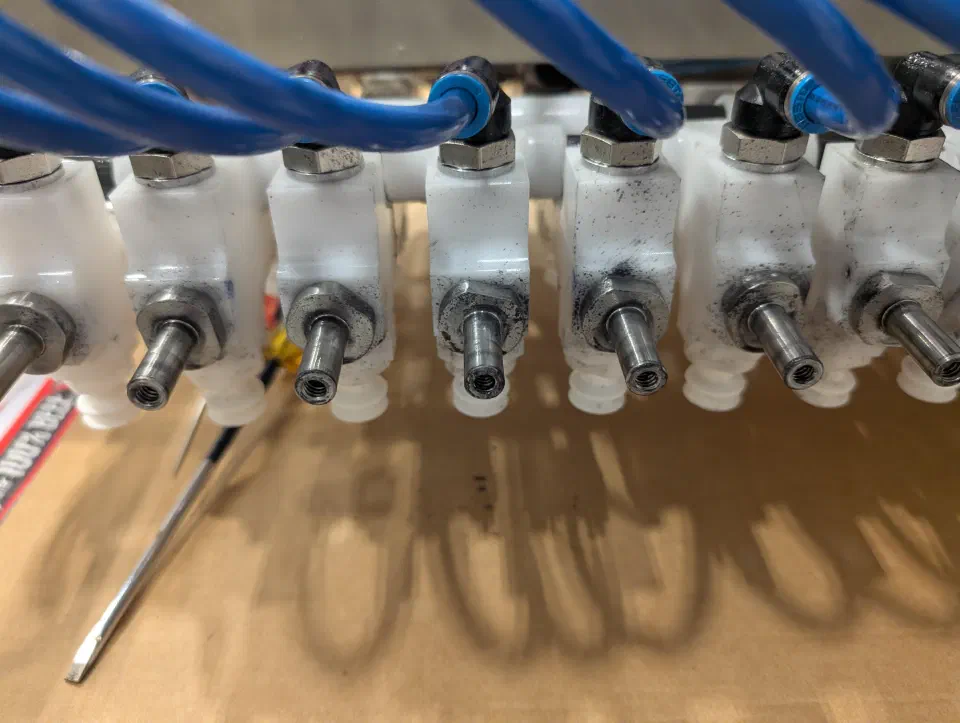 A soiled pneumatic manifold on the end-of-arm tool, from a service visit
