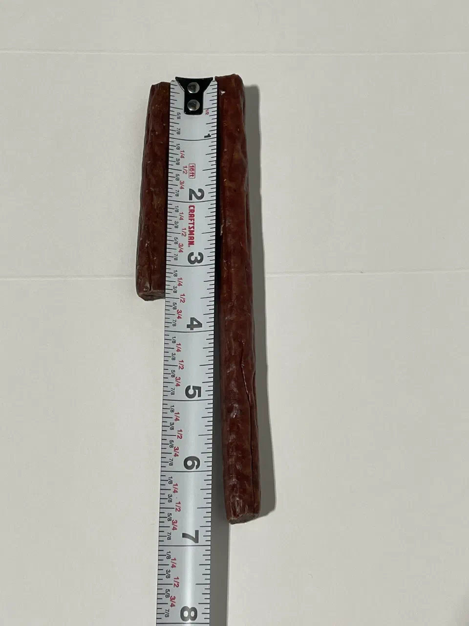 Sample meat sticks against a tape measure, used to size the application
